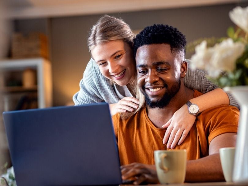 A couple looks at information about a home equity loan on a laptop
